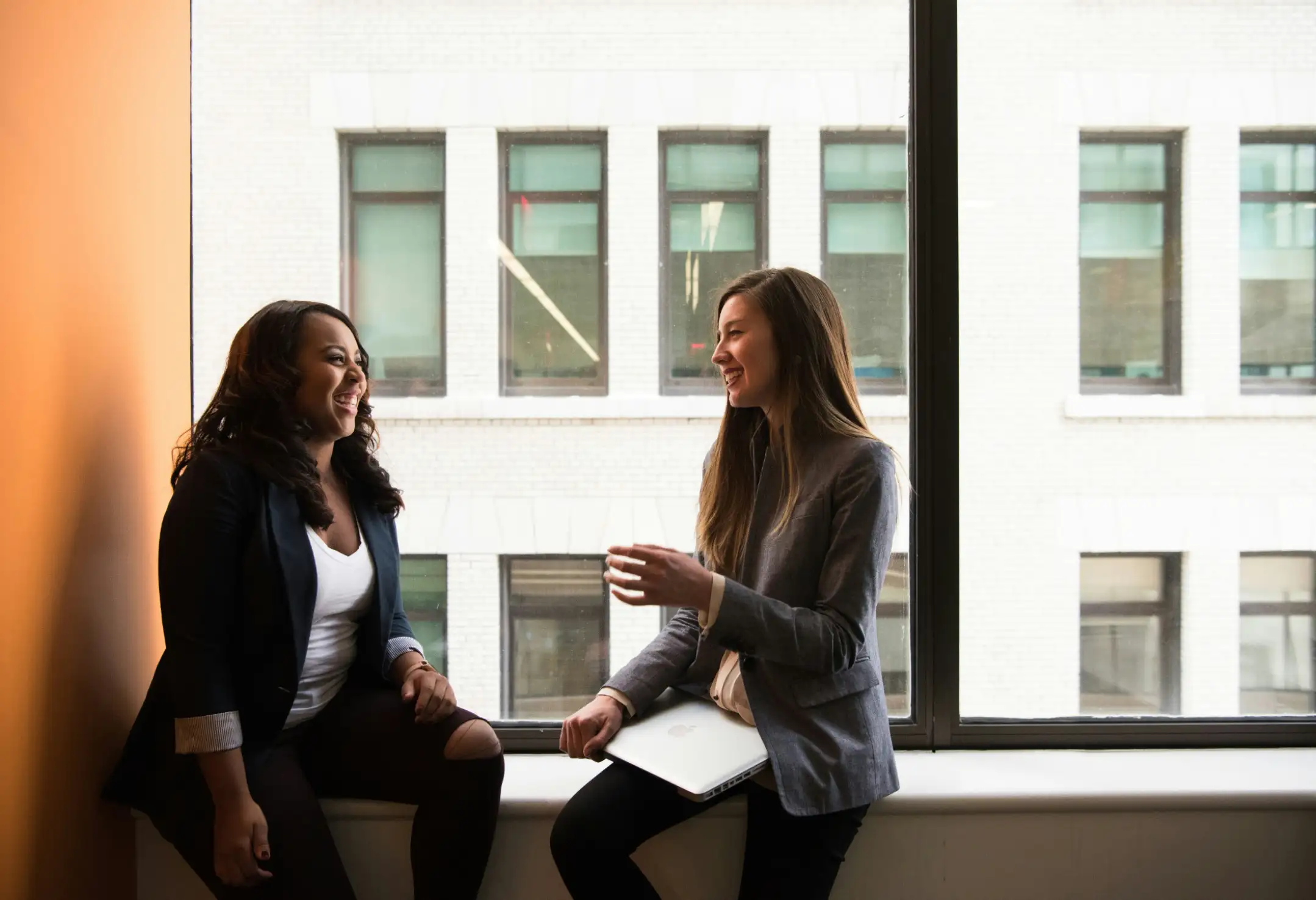 Two women having a discussion in an office setting.